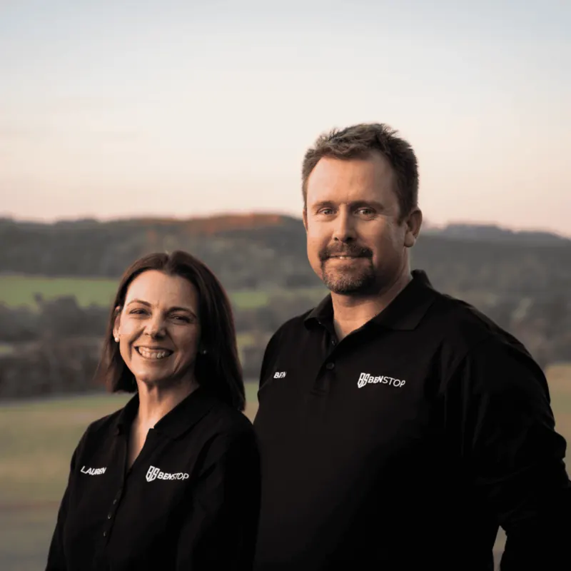 Lauren and Ben Portman, Benstop directors, standing outdoors in Benstop shirts