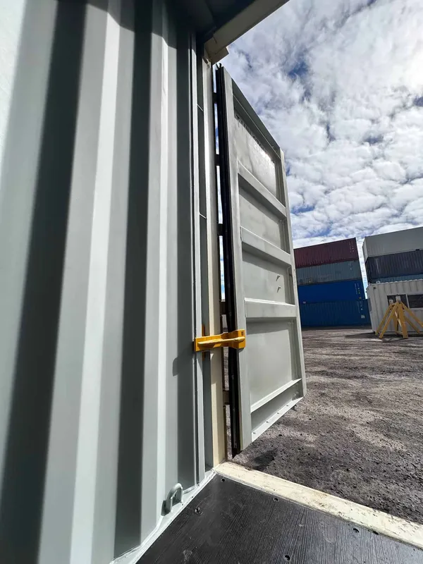 View from inside a container: the open door held steady by a yellow BenStop brace